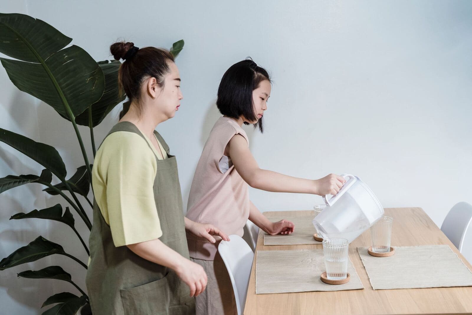 Pouring filtered water into glasses in a modern kitchen